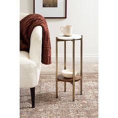 a living room with a chair, table and pictures on the wall