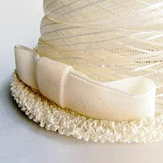 "This vintage women's white cellulosic bucket/cloche/pillbox hat featuring a 5 3/4\" width offset bow and 1 3/4\" height upturned brim is 6\" in height, and 21 3/4\" around the perimeter of the interior comfort band (approximately a size 7 medium)... very avant-garde." Adjustable Cream Hat For Gift, Adjustable Cream Hat For Gifts, Adjustable Cream Hat As Gift, White Adjustable Cloche Mini Hat, Vintage White Mini Hat With Short Brim, Cream Brimmed Mini Hat With Adjustable Fit, White Vintage Top Hat With Curved Brim, Adjustable Vintage Top Hat As A Gift, White Hat With Ribbon And Short Brim