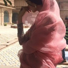 a woman in a pink hijab walking down the street