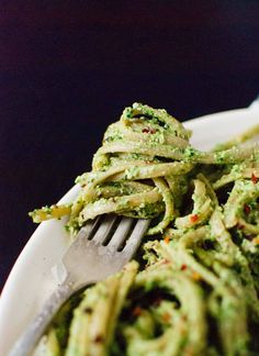 a plate with pasta and broccoli on it is ready to be eaten by someone