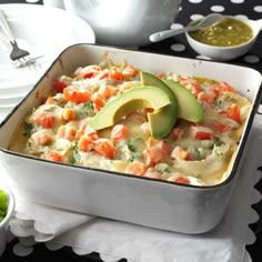 a casserole dish with avocado and shrimp in it on a table