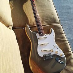 an electric guitar sitting on top of a couch