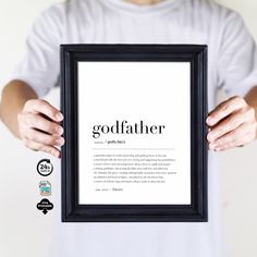 a man holding up a framed poster with the word godfather in it's hands