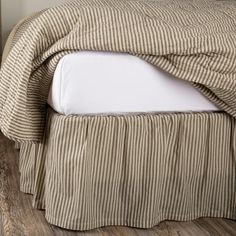 a bed with a brown and white striped bedspread on it's side