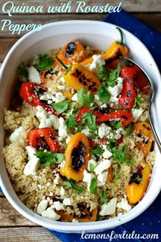 a white bowl filled with rice and vegetables on top of a blue napkin next to a fork