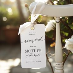 a white chair with a tag that says reserved for the mother of the bride