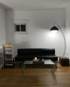 a living room filled with furniture and a lamp on top of a coffee table next to a radiator