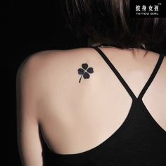 a woman with a four leaf clover tattoo on her back