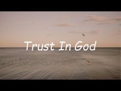 the words trust in god over an ocean