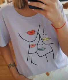 a woman is taking a selfie with her cell phone while wearing a t - shirt