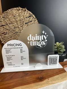 a display case with a price label for dainty tings in front of a black wall