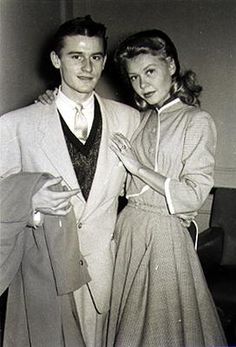 an old black and white photo of a man and woman posing for the camera together