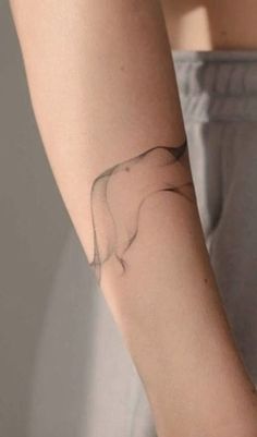 a woman's arm with a small tattoo on the left side of her arm