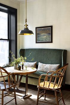 a living room with two chairs and a table in front of a large window next to a couch