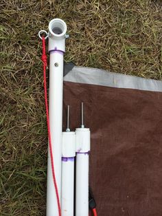 three white pipes laying on the ground next to a piece of brown fabric and some wires