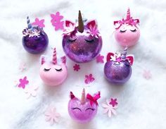 some pink and purple ornaments with unicorn faces on them