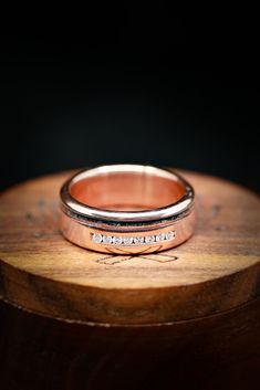 two wedding bands sitting on top of a wooden table