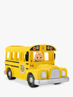 a yellow toy bus with a baby in it's seat on a white background