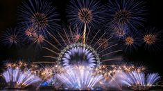 the london eye is lit up with fireworks