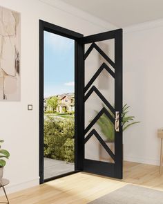 an open black door in a white room with wood flooring and potted plants