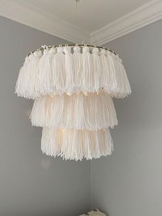 a white chandelier hanging from the ceiling in a child's room with grey walls