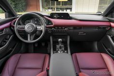 the interior of a car with red and black leather seats, steering wheel and dashboard