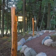 a path in the woods with rocks and lights