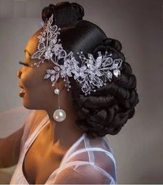 a woman wearing a bridal headpiece with pearls and flowers on it's side