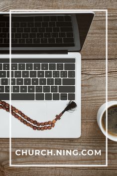 a laptop computer sitting on top of a wooden table next to a cup of coffee