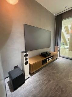 a flat screen tv sitting on top of a wooden entertainment center next to a sliding glass door