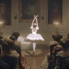 a ballerina is dancing in front of an audience