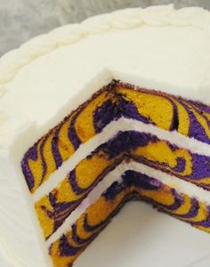 a three layer cake with white frosting and purple swirls on the top half