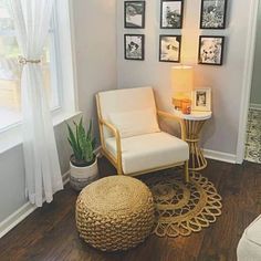 a living room with pictures on the wall and a chair next to a small table