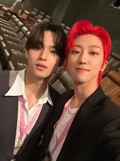 two men with red hair standing next to each other in front of an empty auditorium