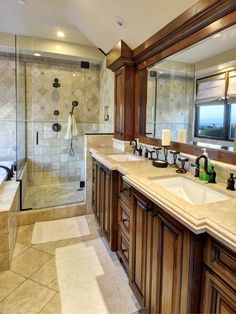 a large bathroom with two sinks and a walk in shower