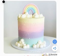 there is a rainbow cake with marshmallows on the bottom and white frosting