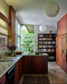 a kitchen with a sink, stove and bookshelf