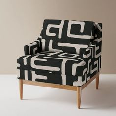 a black and white patterned chair with wooden legs