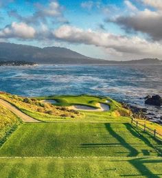 an aerial view of a golf course with the ocean in the background