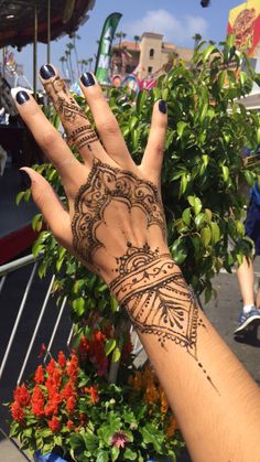 a woman's hand with hendix on it and flowers in the background