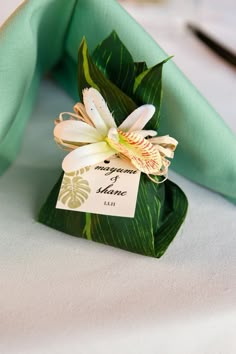 a close up of a napkin with a flower on it and a tag attached to it