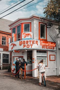 people are standing in front of the lobster potts restaurant on stilts street, with their bikes parked outside