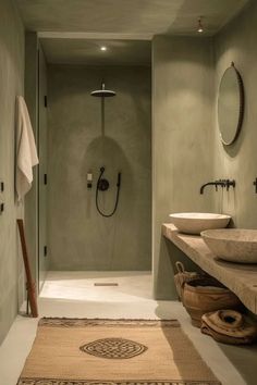 a bathroom with two sinks, a shower and a rug on the floor in front of it