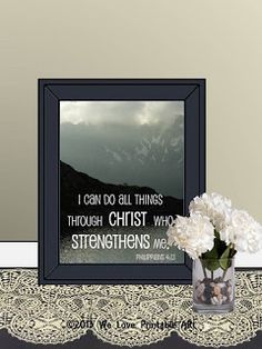 a vase filled with white flowers sitting on top of a table next to a framed photo