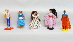 several dolls are lined up on a white surface