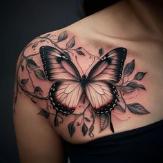 a woman's shoulder with a butterfly tattoo on the chest and leaves around it