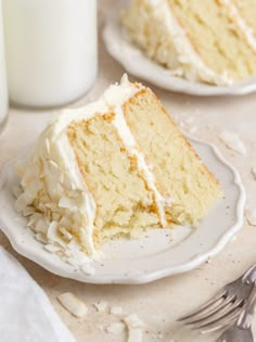 a slice of cake on a plate next to a glass of milk and a fork