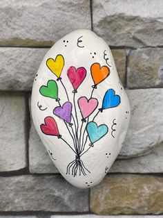 a painted rock with many hearts on it