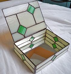 a stained glass box sitting on top of a bed