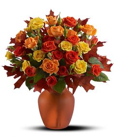 a vase filled with lots of different colored roses and leaves on top of a white background